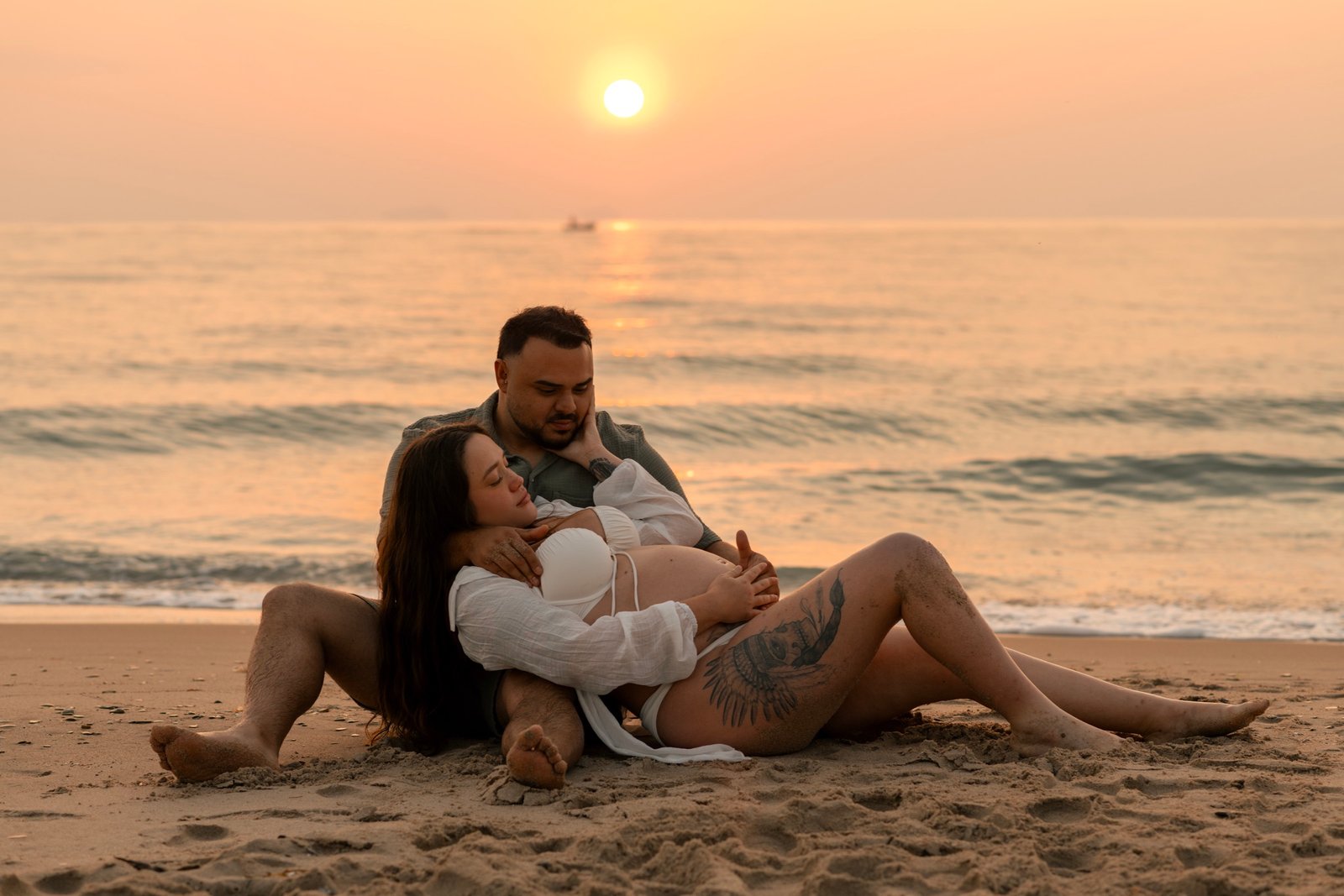 Sesión de embarazo en la playa al atardecer